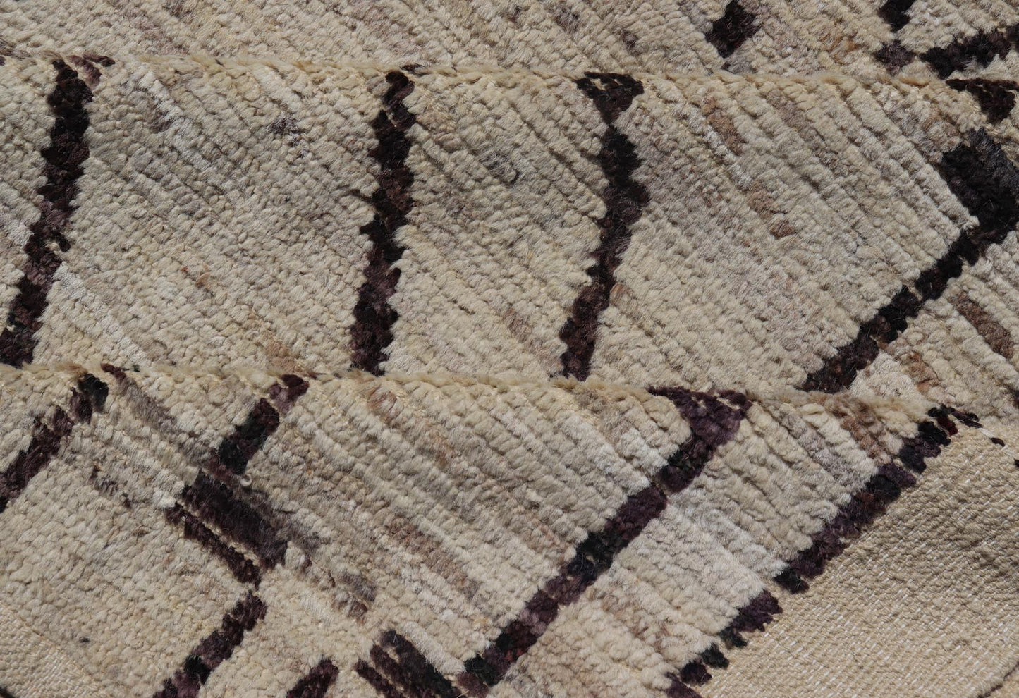 The design of the rug includes a series of interconnected diamond shapes, each containing different motifs such as crosses, zigzags, and other stylized symbols. The central theme is a grid of diamond patterns that vary slightly in size and detail, crea... - Keivan Woven ArtsAFG - 39925 - 19598Rug