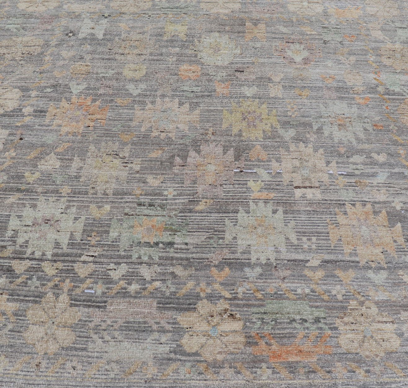 Modern Afghan Tribal Motif Designed Rug in Muted Tones and A Gray Background Measures 7'2 x 8'4 This modern area rug was hand - knotted in Afghanistan during the 2020's. This modern rug does feature a border of modest floral motifs. The gr... - Keivan Woven ArtsAFGC - 39487 - 18565Rug