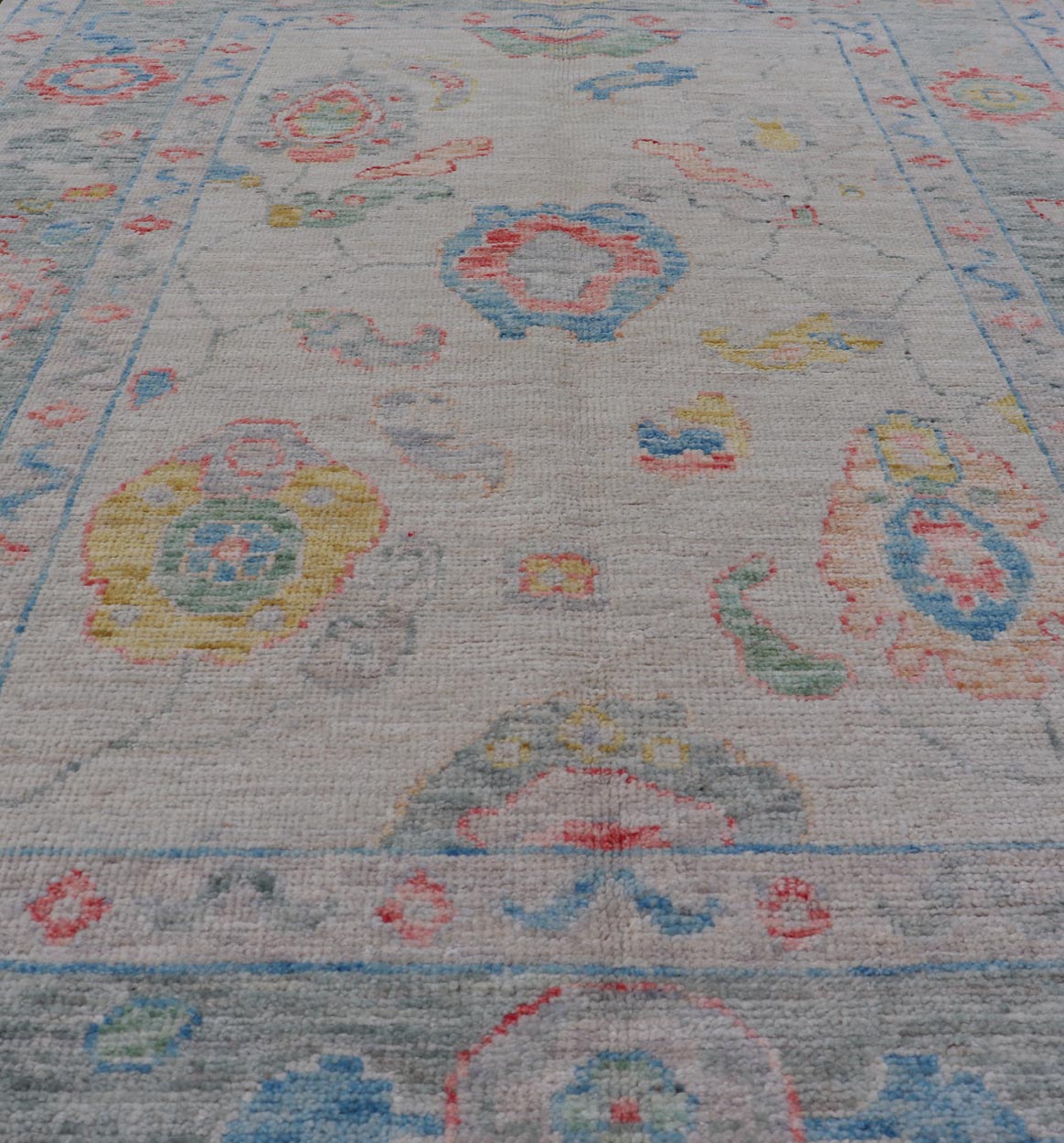 Modern All - Over Floral Oushak with Muted Background and Accent Colors Modern Oushak featuring an all - over, arabesque - like floral design, rendered in saturated oceanic blue, gold, green, red, and red - orange. The background is rendered in a co... - Keivan Woven ArtsAWR - 356 - 19959Rug