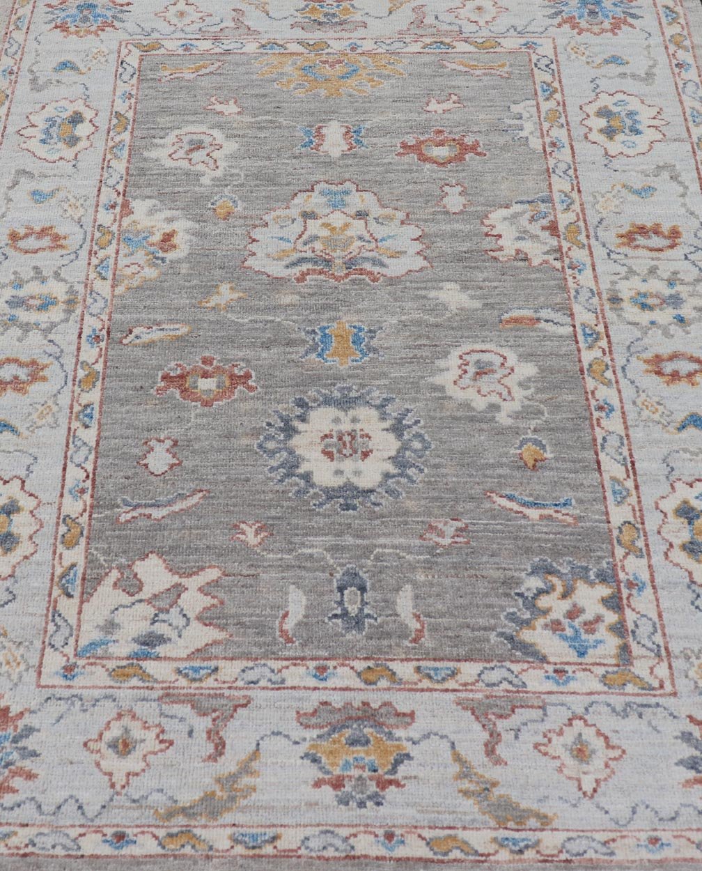 Floral Designed Oushak with Muted Background With Earthy Tones and Soft Blue Modern Oushak featuring an all - over, arabesque - like floral design. The background is rendered in a light gray, while the border is s light pewter blue. The design d... - Keivan Woven ArtsAWR - 6028 - 19971Rug