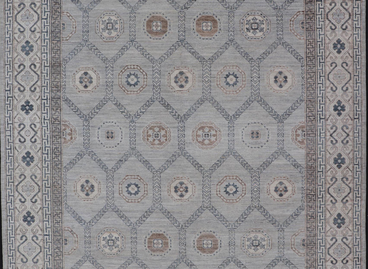Sub - Geometric Mosaic Khotan Rug With Muted Tones of Blue and Brown This hand - knotted Khotan features geometric medallions, each of which hold a small geometric motif. The border hosts different geometric designs on each tier, alternating between... - Keivan Woven ArtsAWR - 6044 - 19989Rug