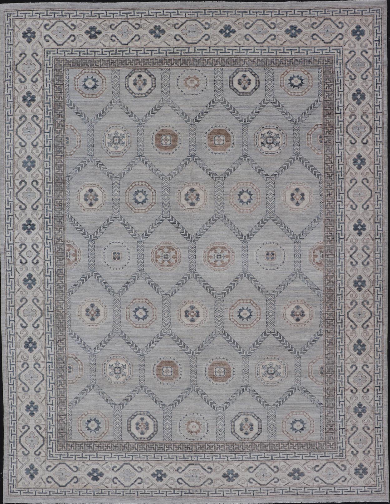 Sub - Geometric Mosaic Khotan Rug With Muted Tones of Blue and Brown This hand - knotted Khotan features geometric medallions, each of which hold a small geometric motif. The border hosts different geometric designs on each tier, alternating between... - Keivan Woven ArtsAWR - 6044 - 19989Rug