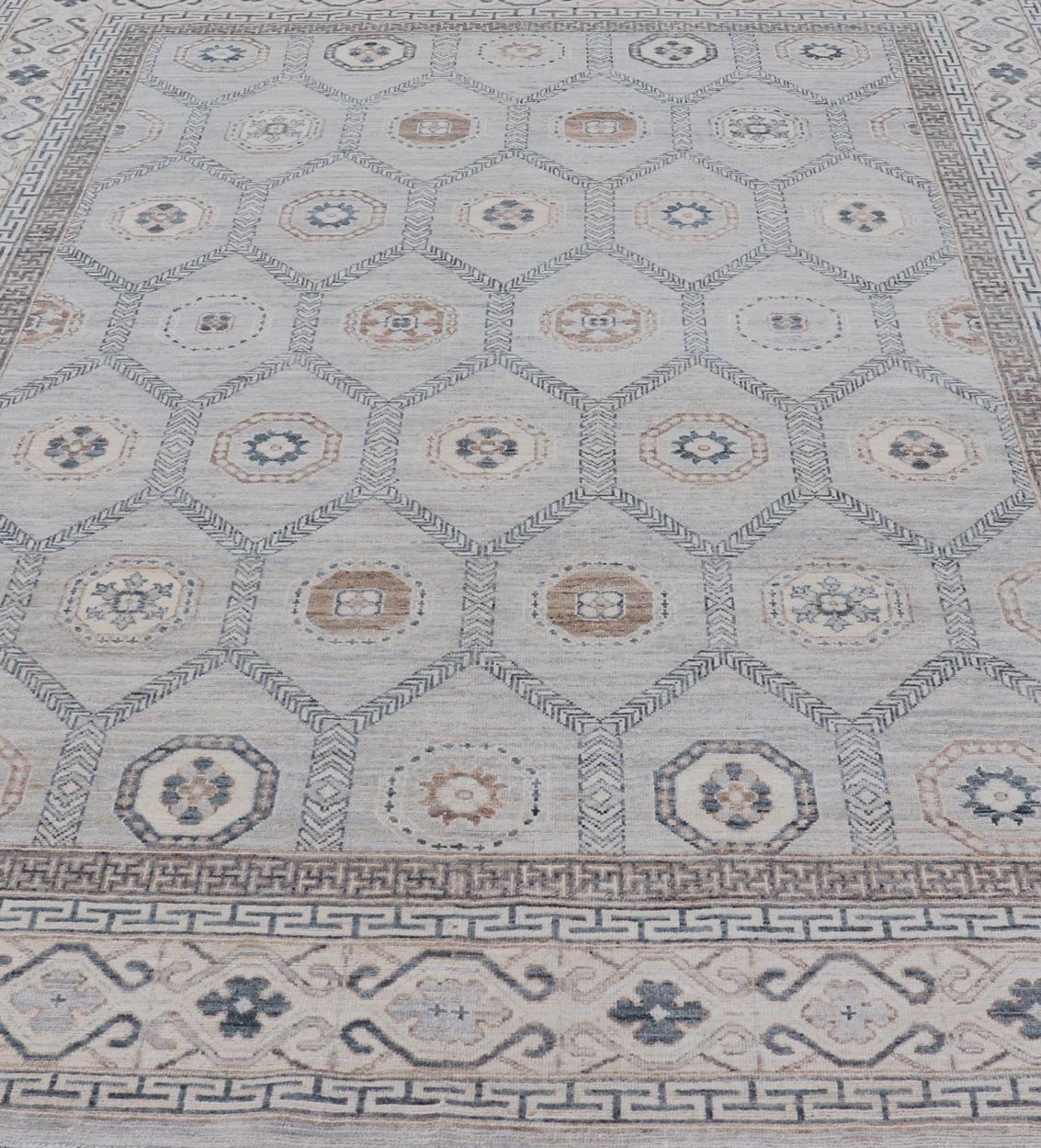 Sub - Geometric Mosaic Khotan Rug With Muted Tones of Blue and Brown This hand - knotted Khotan features geometric medallions, each of which hold a small geometric motif. The border hosts different geometric designs on each tier, alternating between... - Keivan Woven ArtsAWR - 6044 - 19989Rug
