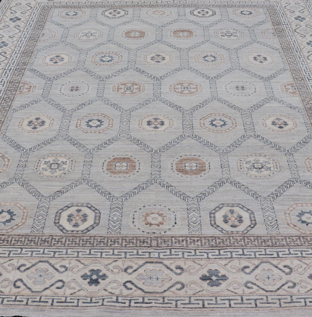 Sub - Geometric Mosaic Khotan Rug With Muted Tones of Blue and Brown This hand - knotted Khotan features geometric medallions, each of which hold a small geometric motif. The border hosts different geometric designs on each tier, alternating between... - Keivan Woven ArtsAWR - 6044 - 19989Rug