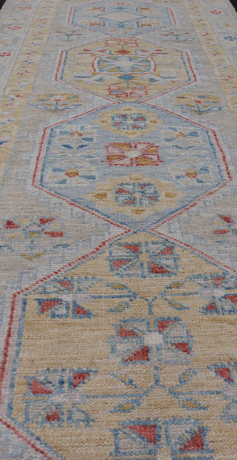 Hand - Knotted Floral Medallion Oushak Runner in Blue and Yellow This piece showcases brilliant medallions encasing star - like motifs in yellow, coral, orange, light blue, and cream. The border displays a yellow band between a cream background.... - Keivan Woven ArtsAWR - 6116 - 20013Rug