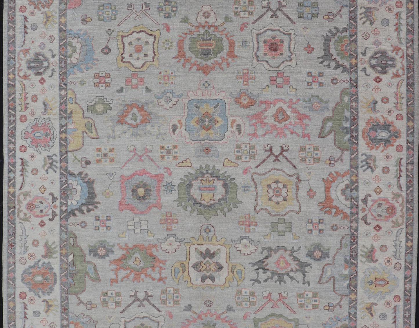 Oushak Floral Motif on Light Grey Background and Colorful Design The border and field are covered in floral - like motifs filled with colors such as pink, green, gold, teal and red - oranges on top of silvery grey background. The border showcases a ... - Keivan Woven ArtsAWR - 6148 - 20025Rug
