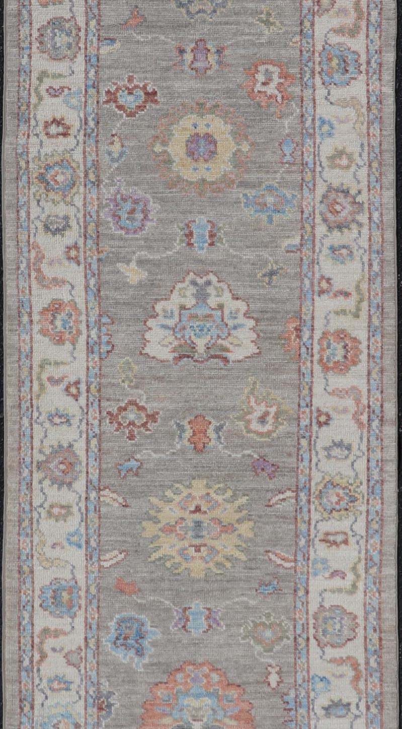 Hand - Knotted Modern Oushak Runner on Light Gray Field and Colorful Motifs This Oushak runner has been hand - knotted. The arabesque motifs scatter atop a light gray background. Within the field, bright displays of gold, teal, blue, pink, maroon, ... - Keivan Woven ArtsAWR - 6196 - 19899Rug