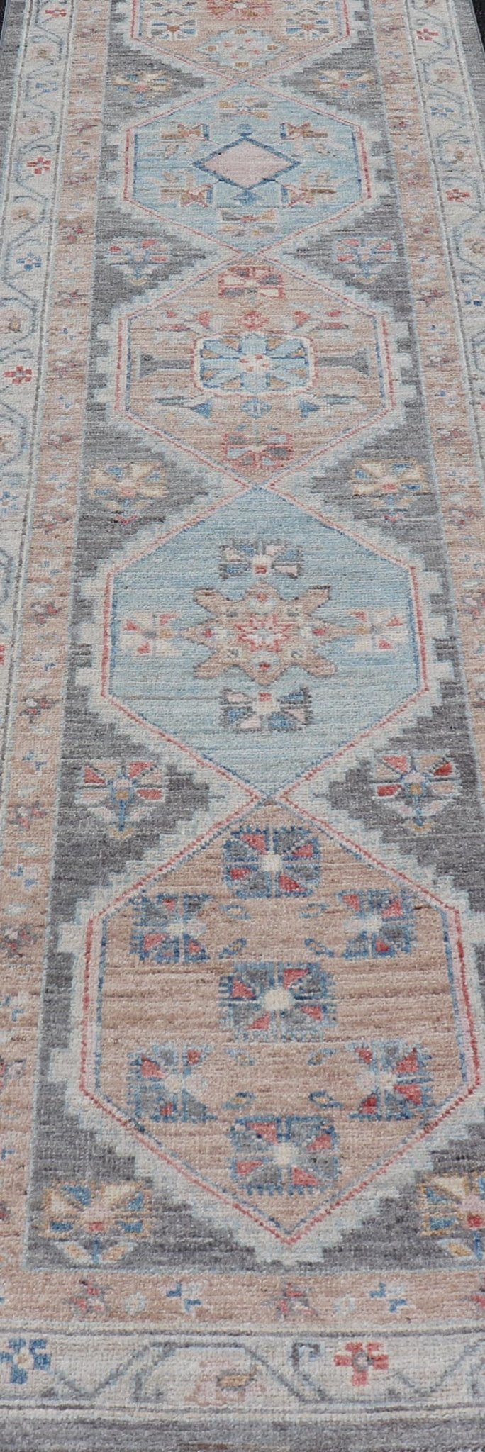 Floral Medallion Oushak Runner With Tribal Motifs and On A Gray Background This Hand - Knotted Afghan Oushak presents a double - lined floral border on top of a dark taupe background, accenting colors such as blue, red, and peach. The field disp... - Keivan Woven ArtsAWR - 6296 - 19905Rug