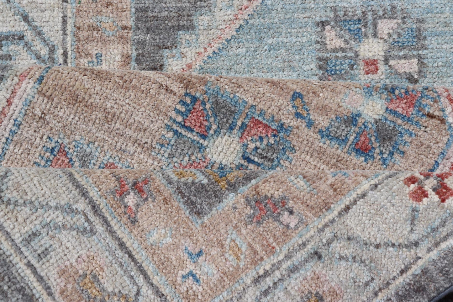Floral Medallion Oushak Runner With Tribal Motifs and On A Gray Background This Hand - Knotted Afghan Oushak presents a double - lined floral border on top of a dark taupe background, accenting colors such as blue, red, and peach. The field disp... - Keivan Woven ArtsAWR - 6296 - 19905Rug