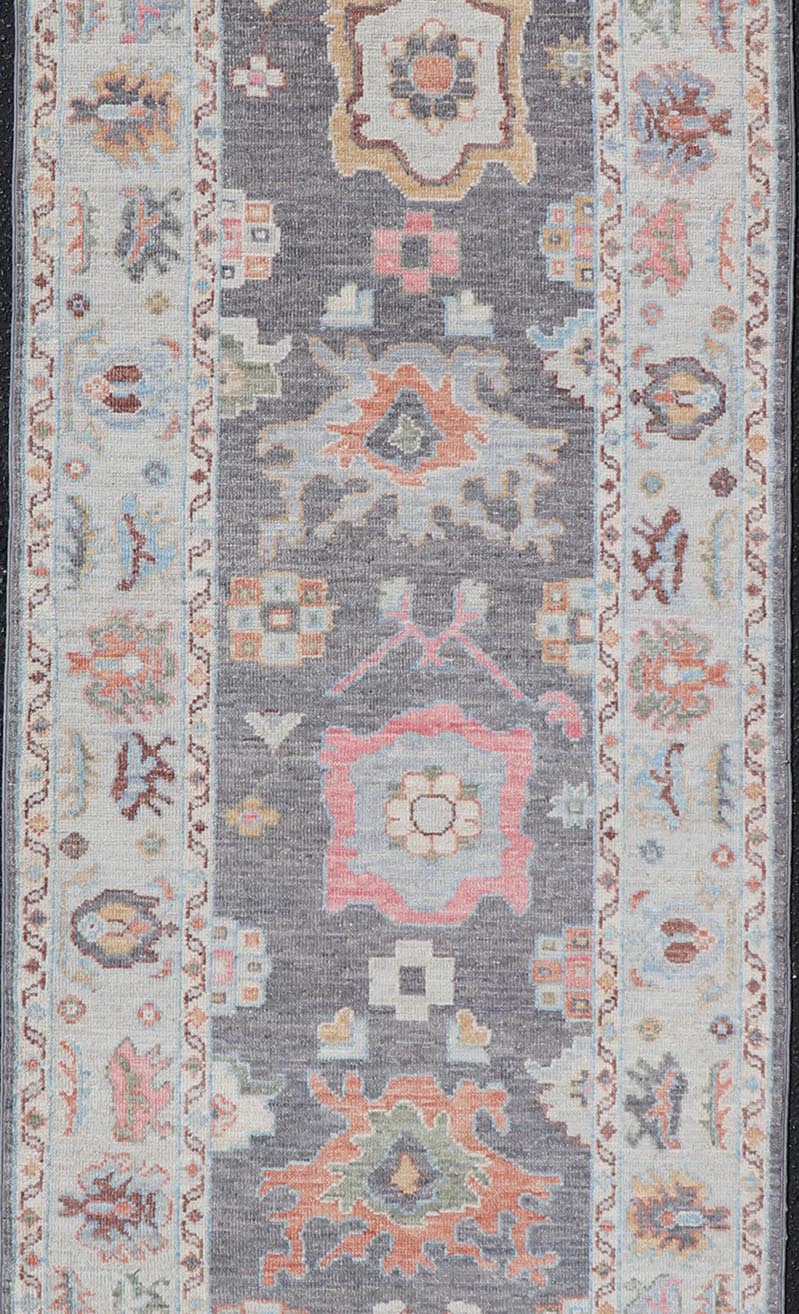 Hand Knotted Afghan Oushak Designed Runner with Gray Background This Afghan Oushak runner features a grand motif, showcasing from the border to the field with a vibrant elegance that pops against the light blue - gray border, as well as the charc... - Keivan Woven ArtsAWR - 6463 - 19911Rug