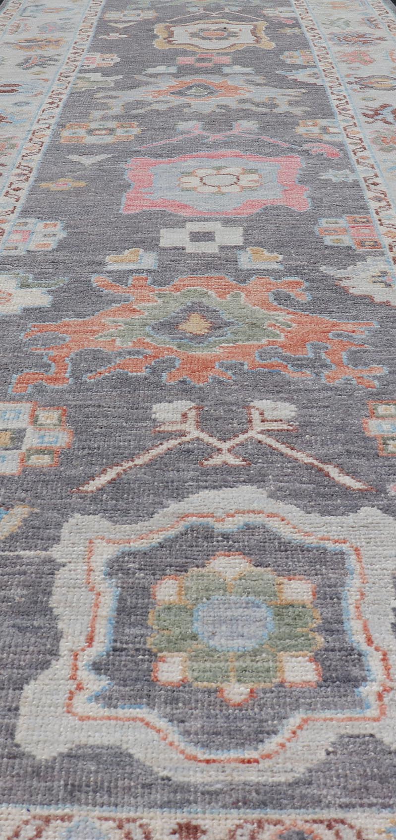 Hand Knotted Afghan Oushak Designed Runner with Gray Background This Afghan Oushak runner features a grand motif, showcasing from the border to the field with a vibrant elegance that pops against the light blue - gray border, as well as the charc... - Keivan Woven ArtsAWR - 6463 - 19911Rug