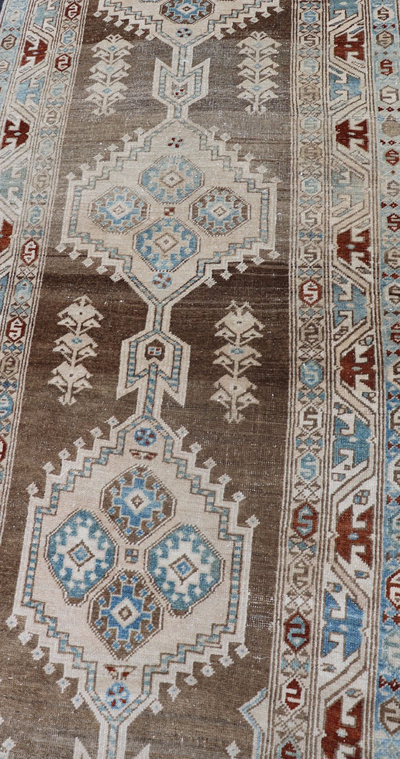 Long Persian Heriz Runner with Central Medallions in Brown, Blue, Tan & Red. Antique Heriz Persian long runner with multi - medallion and geometric design from Persia, rug EMA - 7568 , country of origin / type: Iran / Heriz, circa 1920 This m... - Keivan Woven ArtsEMA - 7568 - 9838Rug