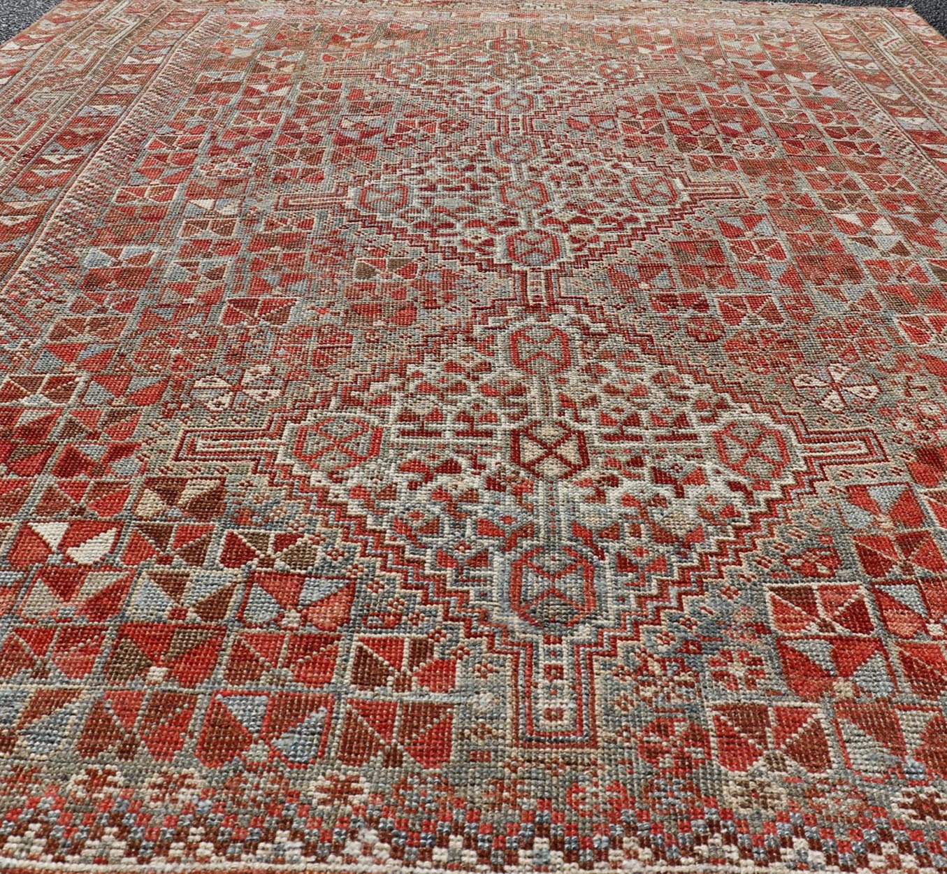 Antique Distressed Persian Medallion Shiraz Rug in Shades Rusty Red & Steel Blue. Keivan Woven Arts / rug EMB - 22190 - 15055, country of origin / type: Iran / Shiraz, circa 1910. Measures: 5'0 x 6'10 This antique distressed Persian Shiraz rug (circ... - Keivan Woven ArtsEMB - 22190 - 15055 - 20565