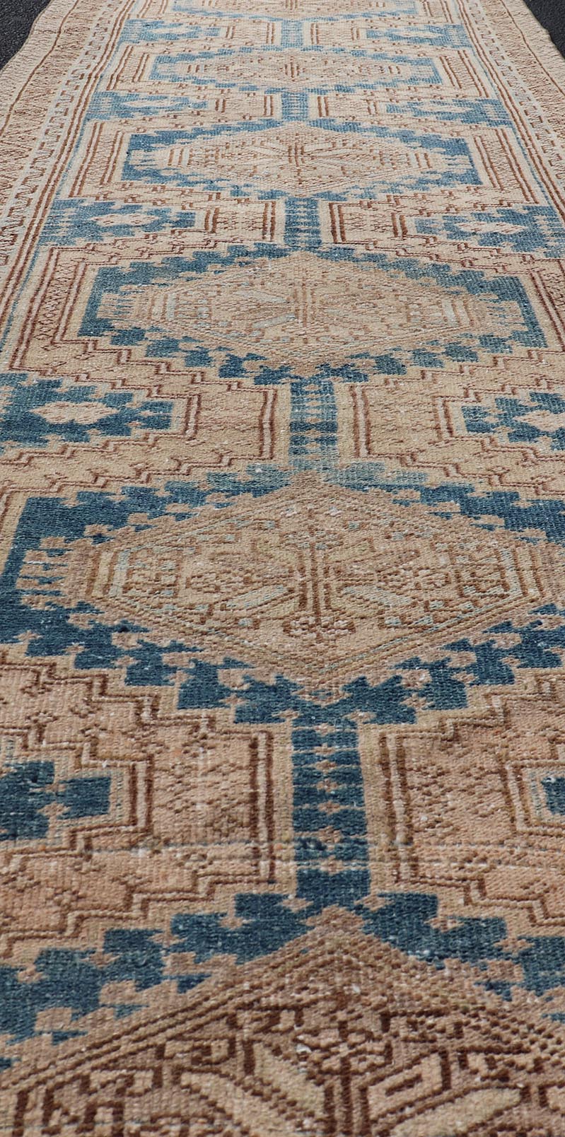 Measures: 3'0 x 10'10 This antique Persian Heriz runner with a distinctive and elegant design. The runner showcases a series of connected geometric medallions running along its length, each intricately detailed with traditional motifs. The central ... - Keivan Woven ArtsEMB - 22240 - 22484Rug