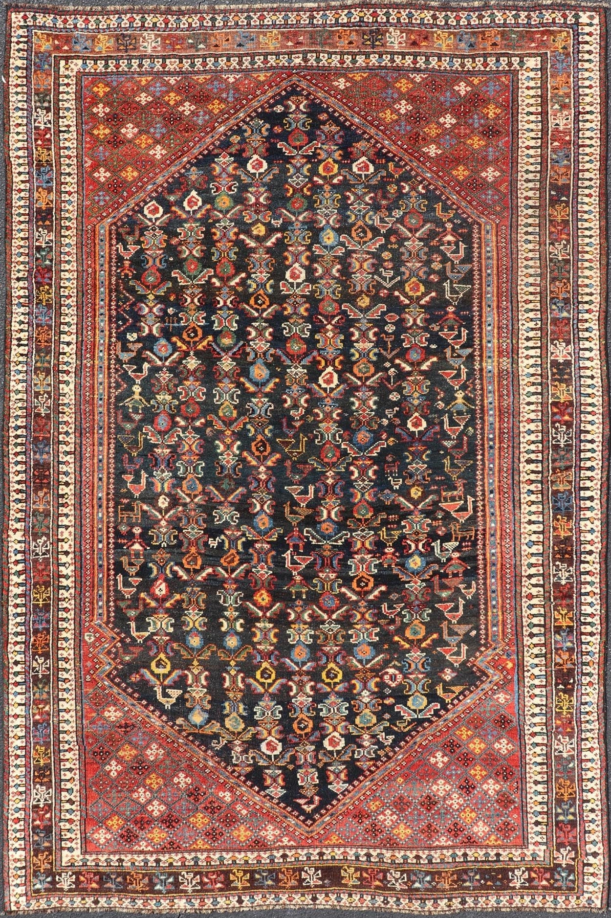 Measures: 5'7 x 8'10 This Qashgai rug has rich heritage and intricate design characteristic of this nomadic tribe from southwestern Iran. The rug features a dense, dark blue field adorned with a myriad of vibrant, detailed motifs, including ani... - Keivan Woven ArtsEMB - 22245 - 22508Rug