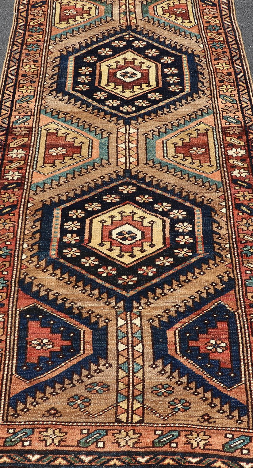 Antique Persian Kurdish Short Runner on Geometric Motifs in Light Camel Field. Medallion design on camel field, with dark blue medallions, green, red, blue , rug EMB - 8546 - 178695, country of origin / type: Iran / Hamedan, circa 1910 This ... - Keivan Woven ArtsEMB - 8546 - 178695 - 13812Rug