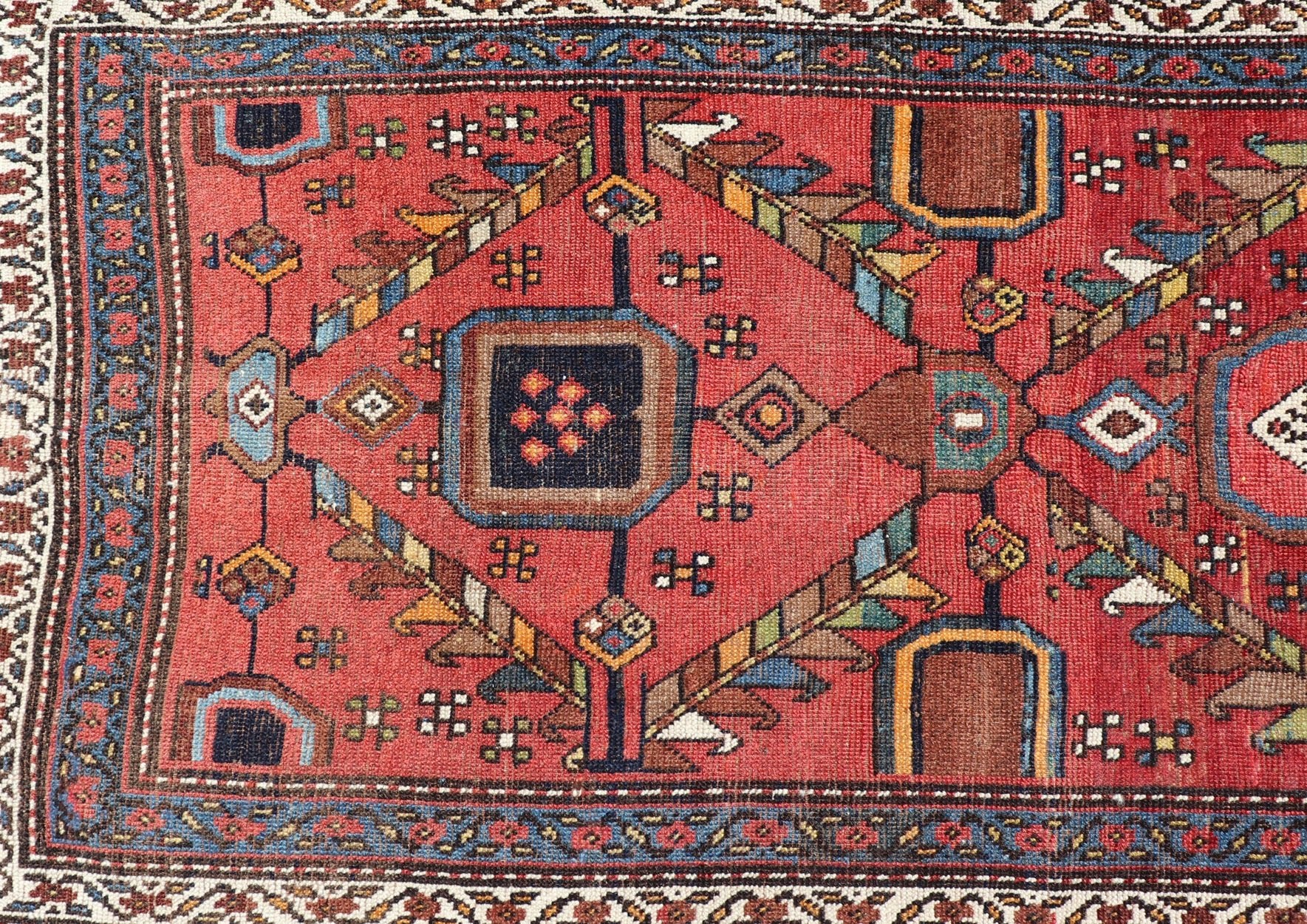 Kurdish Antique Runner in Vibrant Red Background and Multi - tiered Border This early 20th century antique Kurdish runner features a triple - lined floral border, emboldening an ivory stripe between two blue edges. The field features a tribal, sub - g... - Keivan Woven ArtsEMB - 9523 - P13064 - 14668Rug