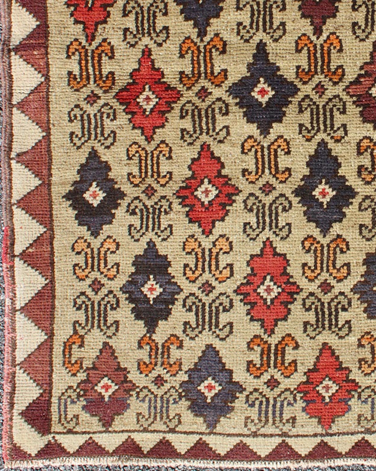 Colorful Midcentury Turkish Tulu Rug with Repeating Design Set on Wheat Field kwarugs Colorful midcentury Turkish Tulu rug with Repeating design set on wheat field, rug en - 1023, country of origin type: Turkey Oushak, circa 1950. This Tulu... - Keivan Woven ArtsEN - 1023 - 4462Rug