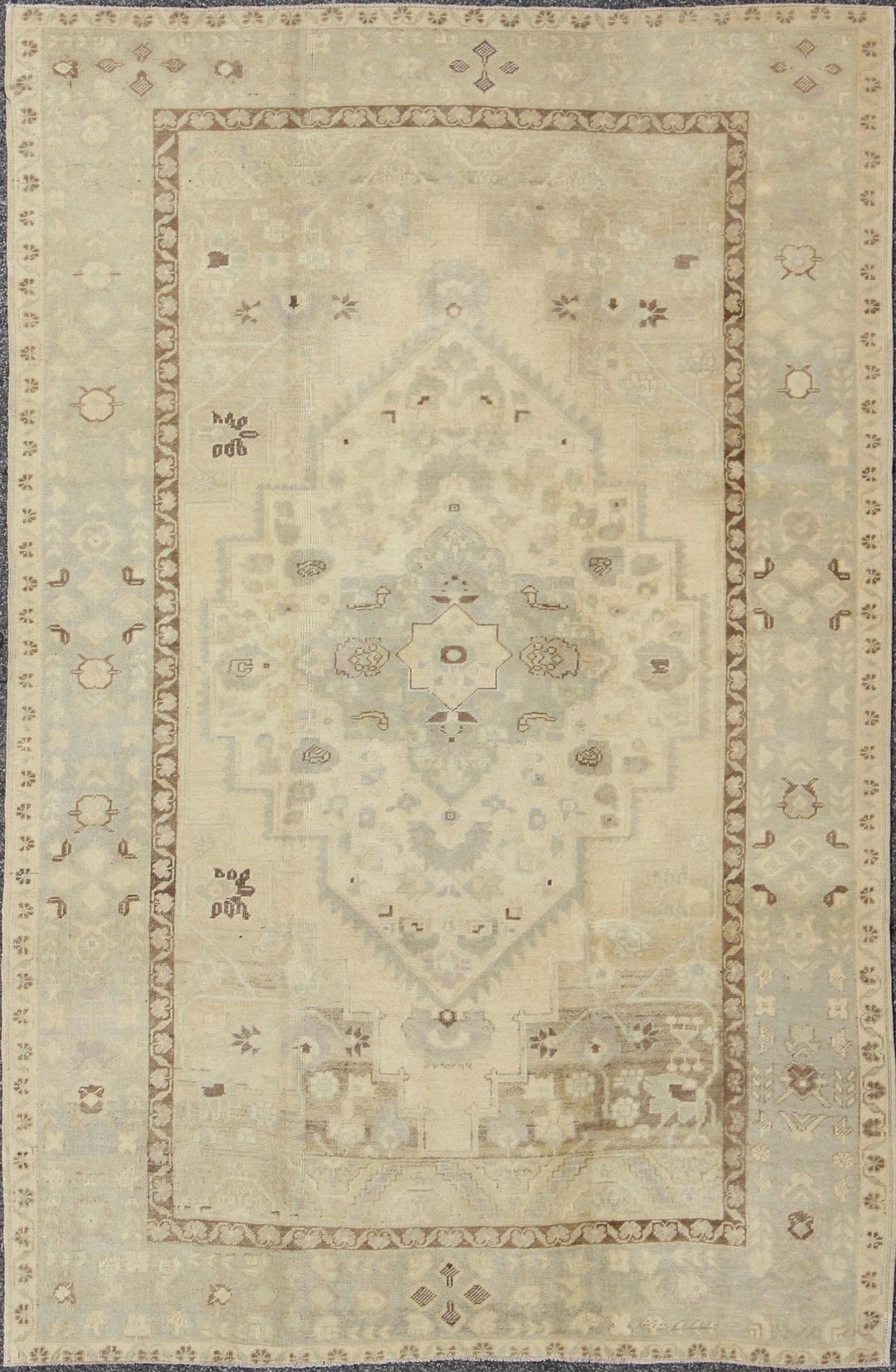 Turkish Oushak This stunning Turkish Oushak displays a gray/blue border and taupe background with brown highlights. The bold geometric design is softened by the use of subdued and pale colors. Measures: 6'4 x 9'4. - Keivan Woven ArtsEN - 112721 - 4900Rug