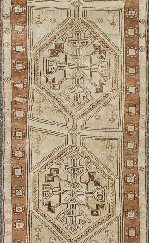 Brown, Camel, Ivory Long Turkish Oushak Runner with Geometric Tribal Medallions This vintage Turkish Oushak gallery rug (circa mid - 20th century) features a unique blend of colors and an intricately beautiful design. The central medallions consis... - Keivan Woven ArtsEN - 142368 - 8379Rug