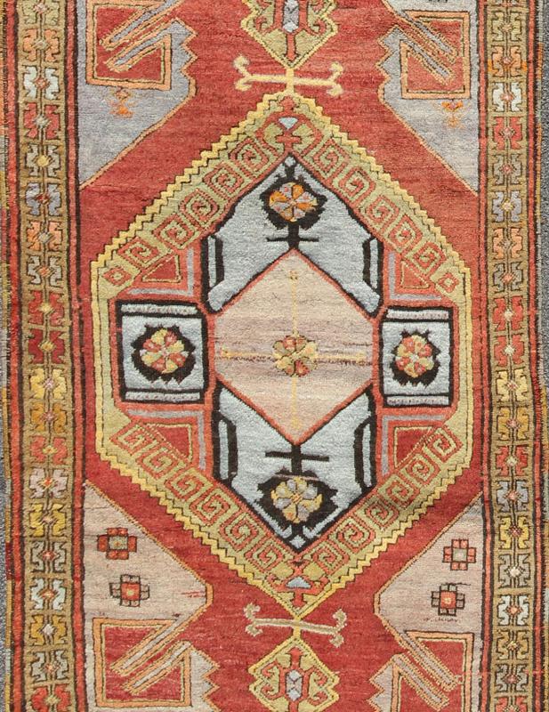 Vintage Turkish Hand Knotted Oushak Long Gallery Rug With Two Tribal Medallions The various shades of red pair elegantly with the bold tones of light blue, yellow and charcoal, laid out over two large tribal medallions with motifs in the field.... - Keivan Woven ArtsEN - 142374 - 8062Rug