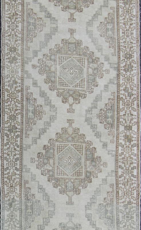 Vintage Oushak Runner with Central Medallions and Ornate Border Measures: 3'0'' x 12'3''. This beautiful vintage Oushak runner features a classic Oushak design, which is enhanced by lustrous wool. The faint ivory ground is home to six large a... - Keivan Woven ArtsEN - 142470 - 7855Rug