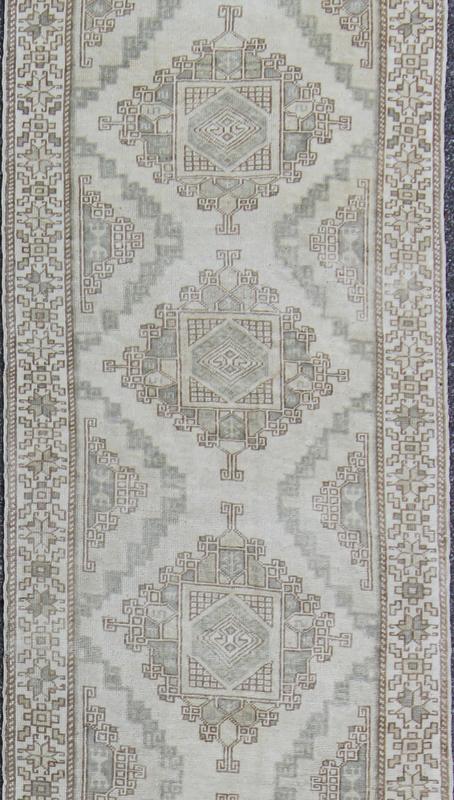 Vintage Oushak Runner with Central Medallions and Ornate Border Measures: 3'0'' x 12'3''. This beautiful vintage Oushak runner features a classic Oushak design, which is enhanced by lustrous wool. The faint ivory ground is home to six large a... - Keivan Woven ArtsEN - 142470 - 7855Rug