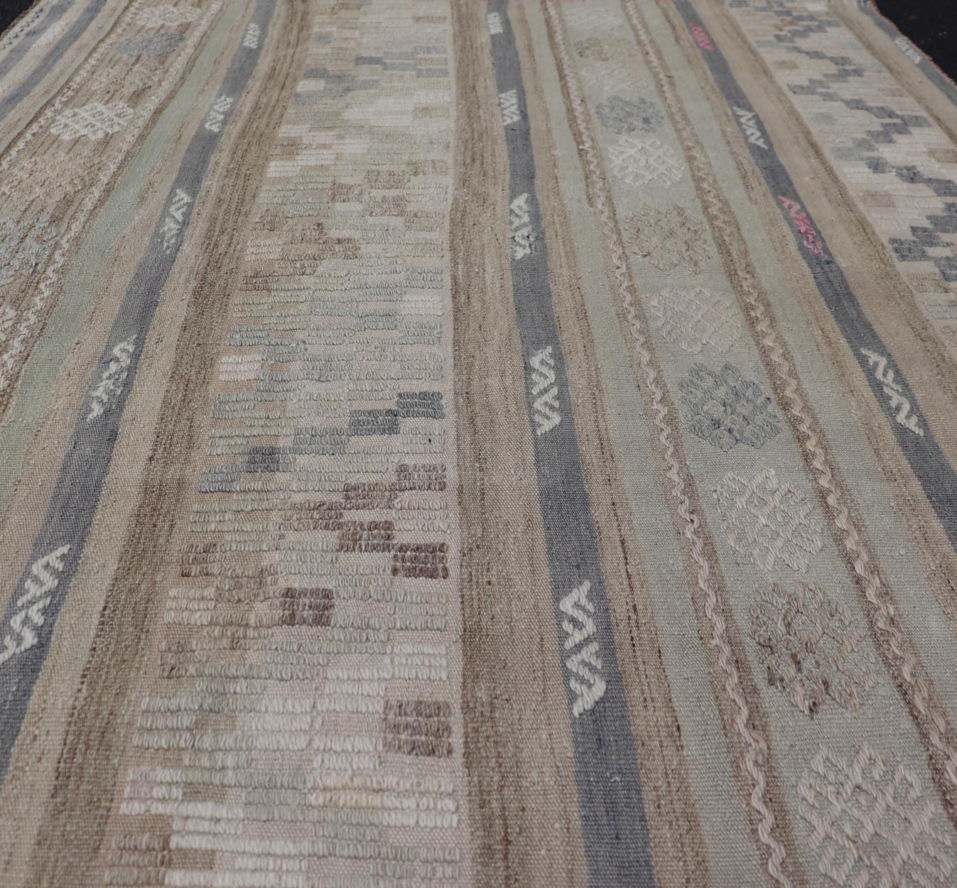 This flat - woven Kilim from Turkey features an enticing composition consisting of stripes with fascinating geometric designs rendered in natural tones of brown and gray, as well as some light green shades. Vintage Kilim with Stripes and Geometri... - Keivan Woven ArtsEN - 14668 - 23971Rug