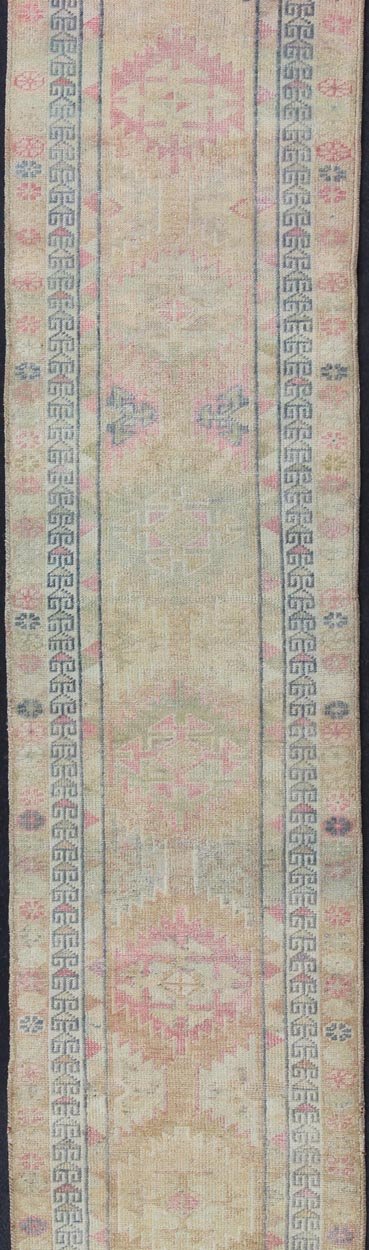 Oushak runner with tribal motifs in blue and pink, rug EN - 165353, country of origin / type: Turkey / Oushak, circa 1960 This Oushak runner from Turkey is characterized by a neutral - toned background and an assortment of tribal designs and flowers... - Keivan Woven ArtsEN - 165353 - 11421Rug