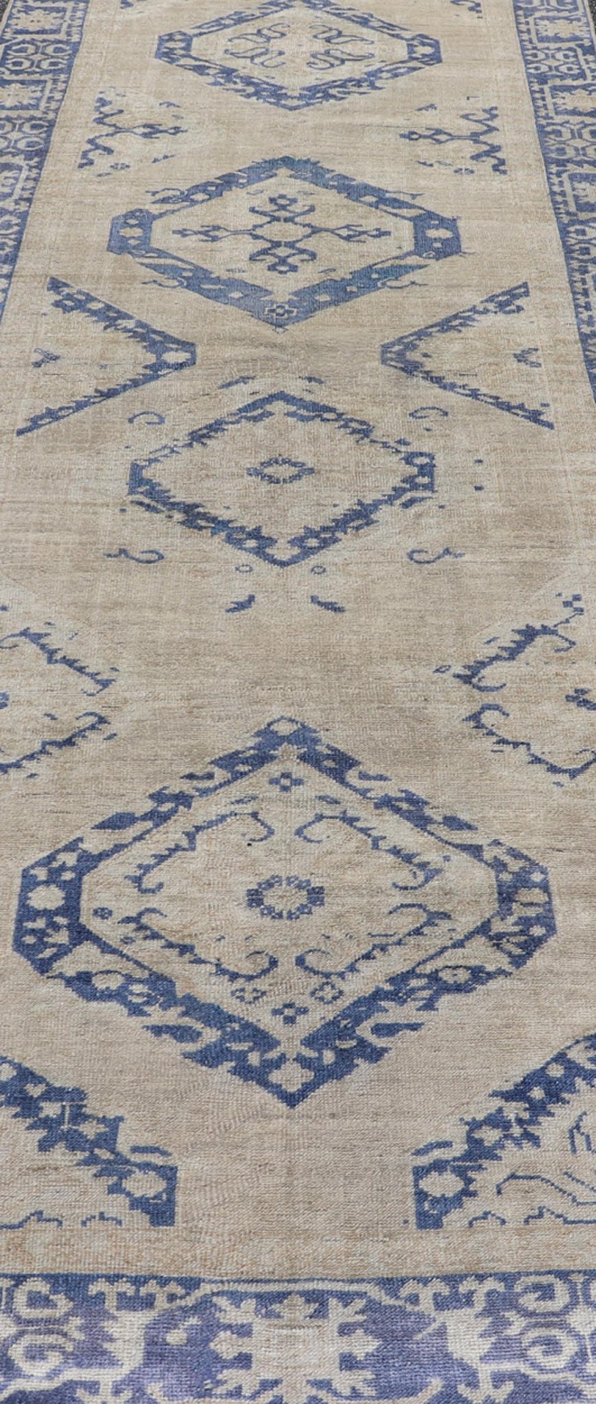 Turkish Oushak Gallery Rug in Blue and Cream with Geometric Design Measures: 4'6 x 12'6 This vintage Oushak gallery runner features blue medallions on a sandy - taupe field. The border and central medallions are both rendered in a rich me... - Keivan Woven ArtsEN - 178699 - 18896Rug