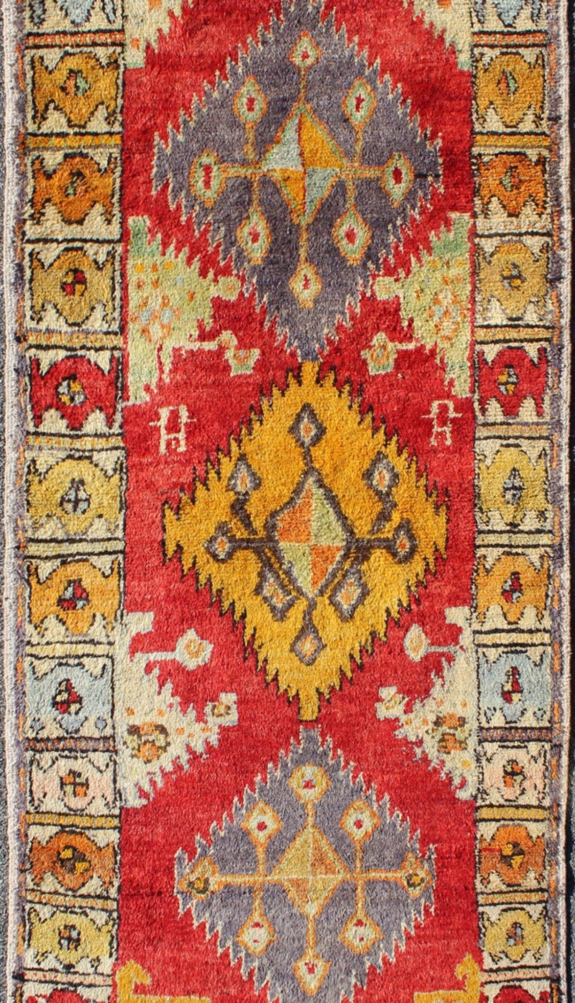 Tribal Turkish Oushak Runner This cheerful Oushak runner contains a unique blend of colors along with geometric design. The multi - layered diamond medallions are complemented by asymmetrical and tribal motifs. The various shades of yellow, gold, ... - Keivan Woven ArtsEN - 3308 - 5498Rug