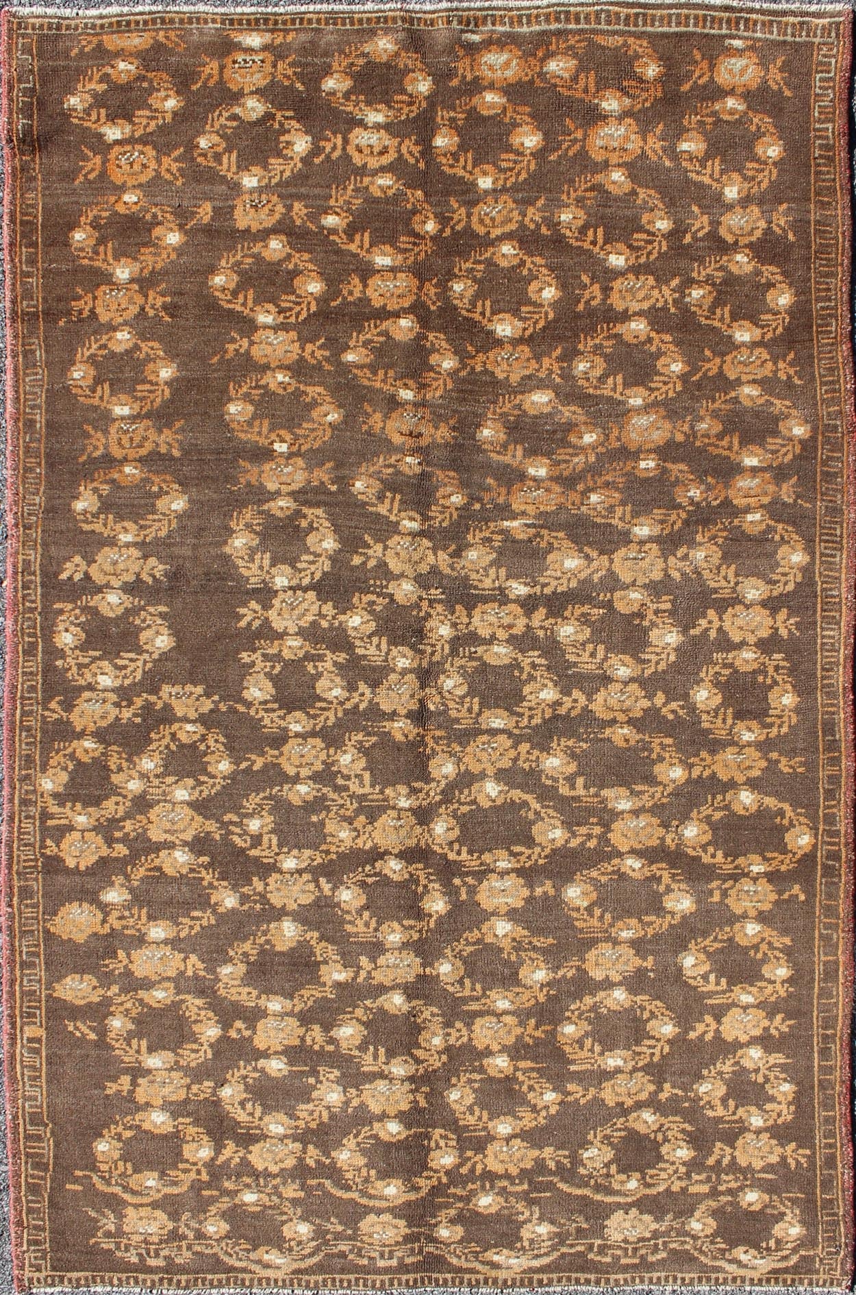 All - Over Floral Wreath Design Turkish Oushak Rug with Brown Background Measures: 4'5 x 7'4 The design of this beautiful vintage Oushak rug from mid - 20th century Turkey is enhanced by its rich colored wool. The brown ground is home to an a... - Keivan Woven ArtsEN - 534 - 3678Rug