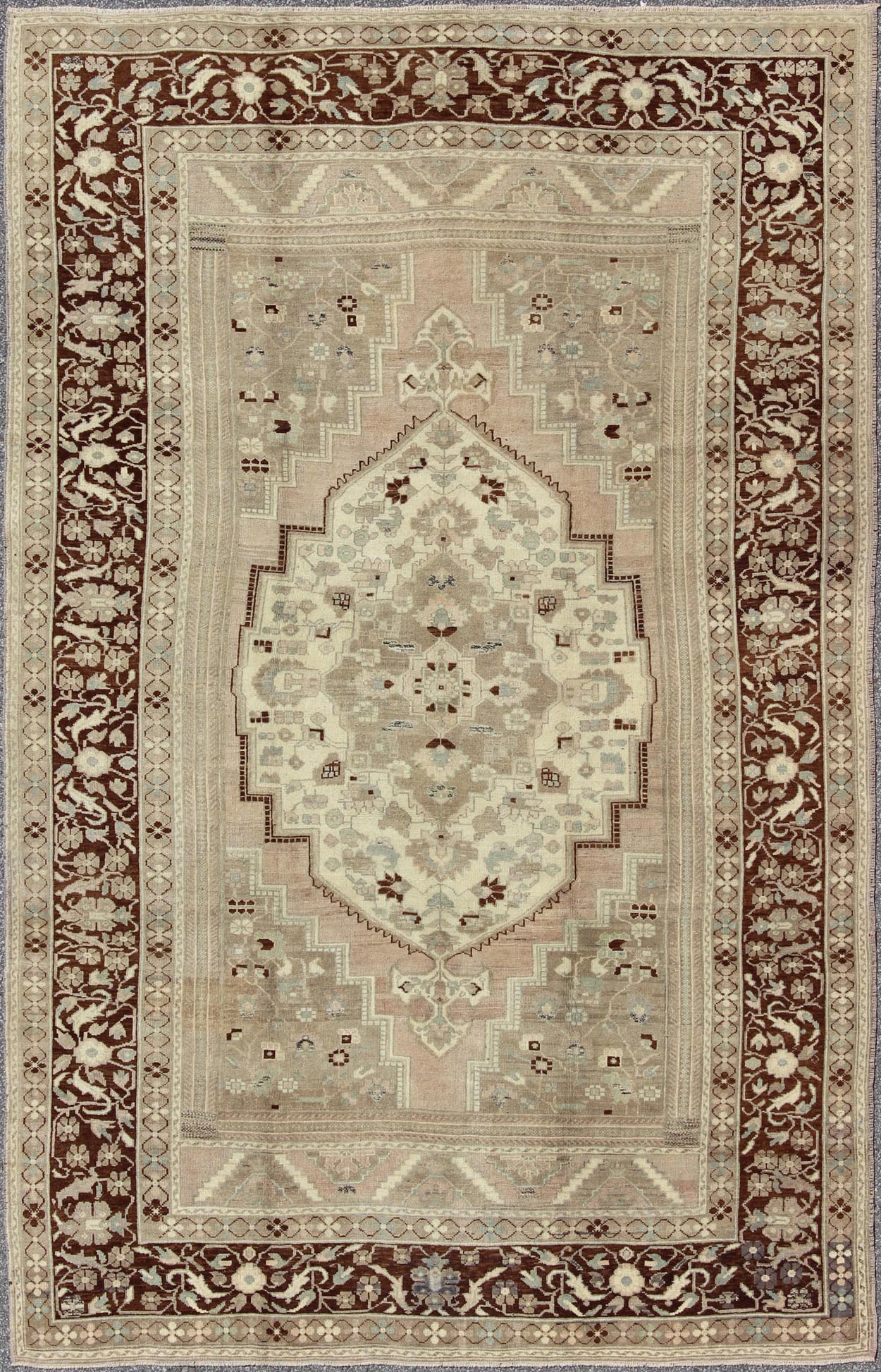 Charming Vintage Oushak Rug in Brown Border, Taupe, Blush and Gray/Green This rug showcases a large central medallion surrounded by a gentle pink color. A cream medallion is filled with floral designs of pale blue, light green, and shades of ne... - Keivan Woven ArtsEN - 786 - 3806Rug