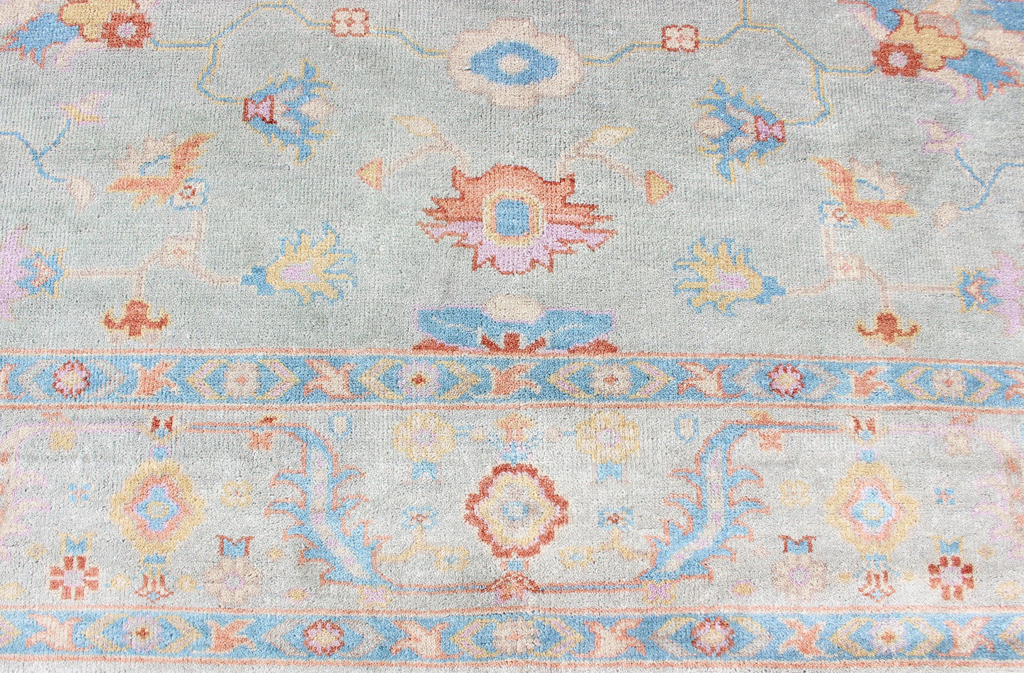 Hand - Knotted Floral Oushak Designed Rug in Light Blue, Orange, and Blue Measures 9'1 x 11'8 This wool Oushak was hand - knotted in the 2020's. The field and border both have a cool blue gray. The field and border also share floral and leaf... - Keivan Woven ArtsIN - CLR - 1002 - 13444