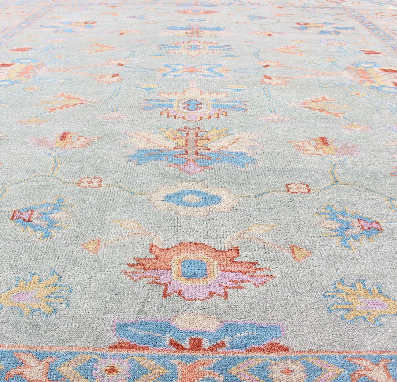 Hand - Knotted Floral Oushak Designed Rug in Light Blue, Orange, and Blue Measures 9'1 x 11'8 This wool Oushak was hand - knotted in the 2020's. The field and border both have a cool blue gray. The field and border also share floral and leaf... - Keivan Woven ArtsIN - CLR - 1002 - 13444