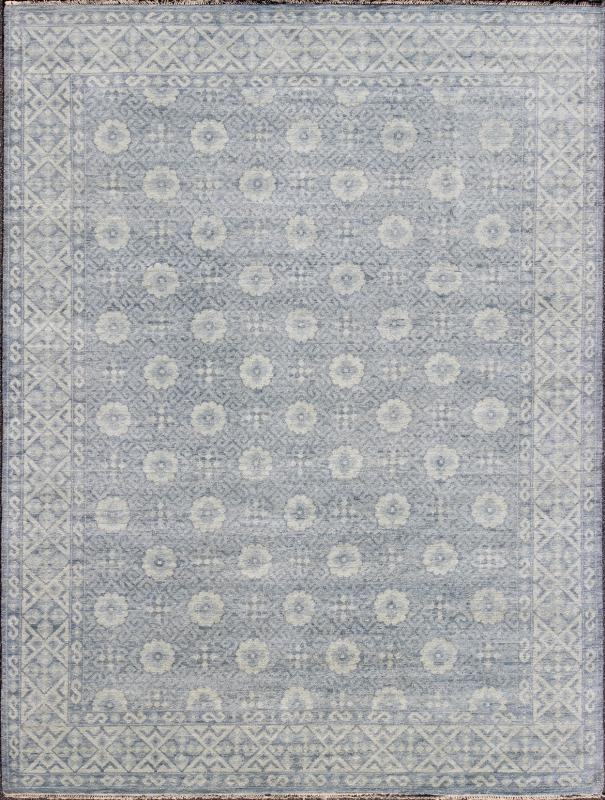Vintage Khotan Rug in White and Blue. Measures: 9'2 x 12'1. This superb woolen Khotan hailing from India features an all over design with geometric shapes and patterning enclosed within a complementary border. The rug is rendered in shades of whi... - Keivan Woven ArtsIN - JAI - 5385 - 6967Rug