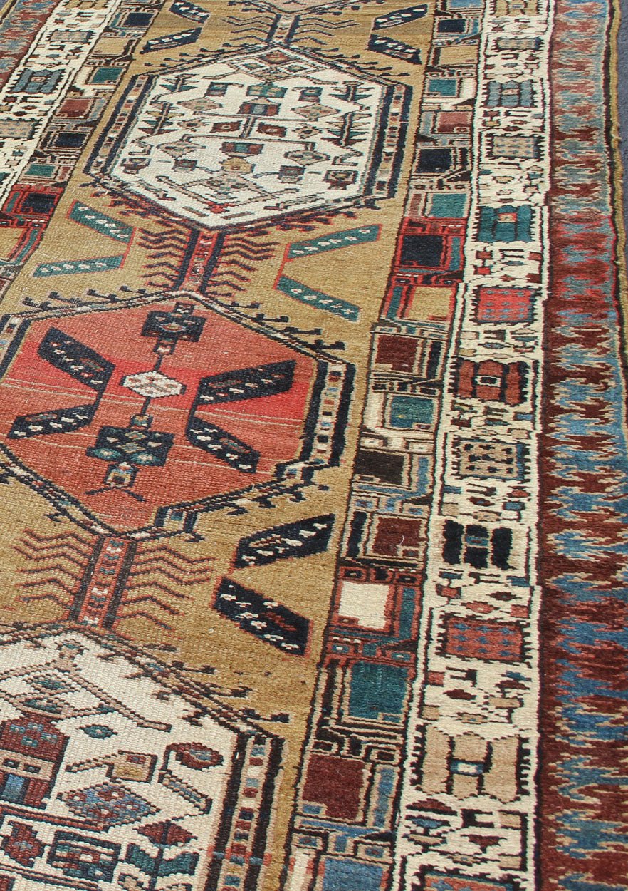 Long Tribal Persian Serab Runner The camel field in this piece is decorated with ivory strap work, navy blue lattice work and stylized Boteh and floral elements. A beautifully drawn Reciprocal Trefoil guard border is complemented by an ivory min... - Keivan Woven ArtsN15 - 0501 - 7695Rug