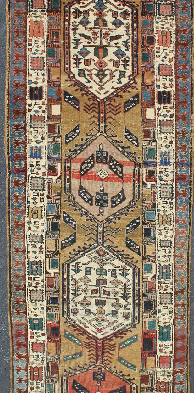 Long Tribal Persian Serab Runner The camel field in this piece is decorated with ivory strap work, navy blue lattice work and stylized Boteh and floral elements. A beautifully drawn Reciprocal Trefoil guard border is complemented by an ivory min... - Keivan Woven ArtsN15 - 0501 - 7695Rug