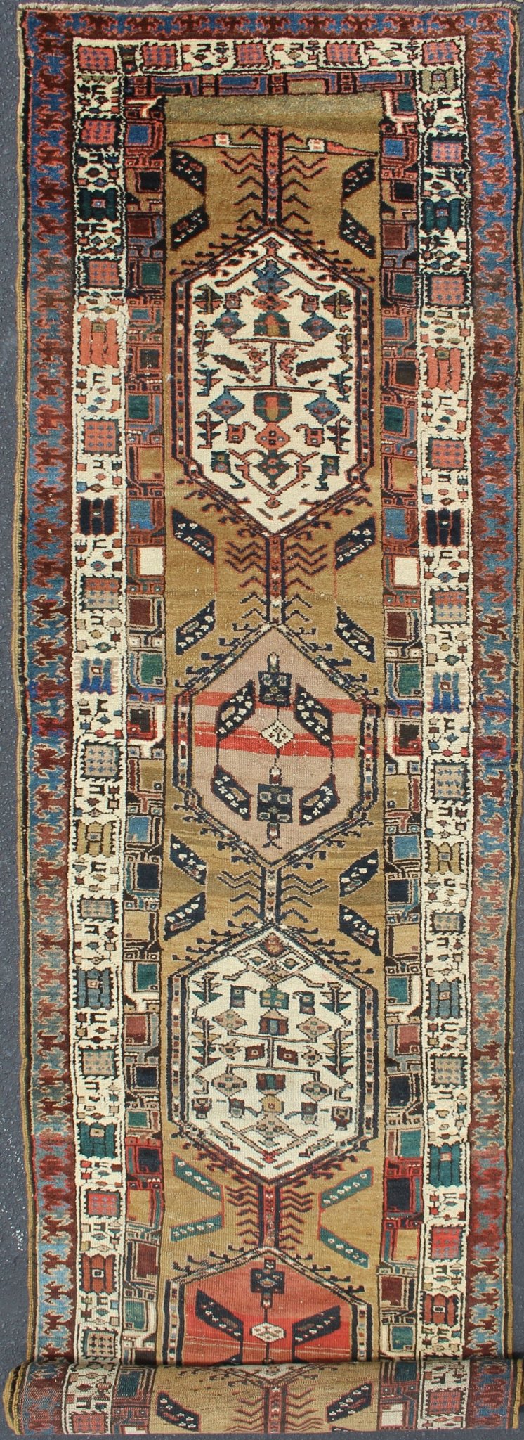Long Tribal Persian Serab Runner The camel field in this piece is decorated with ivory strap work, navy blue lattice work and stylized Boteh and floral elements. A beautifully drawn Reciprocal Trefoil guard border is complemented by an ivory min... - Keivan Woven ArtsN15 - 0501 - 7695Rug