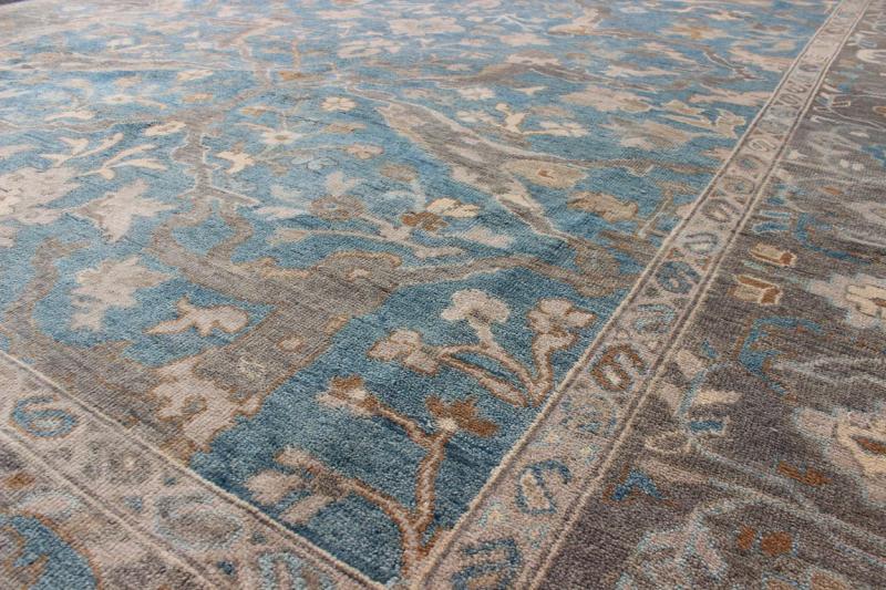 Blue and Gray Vintage Oushak Rug. Measures: 9' x 12'. This vintage Oushak carpet from Turkey features a all over traditional Oushak design rendered in tones of blue and gray, set atop a blue background. The central field features floating motifs ... - Keivan Woven ArtsOB - 9458373 - 06470003 - 8175Rug