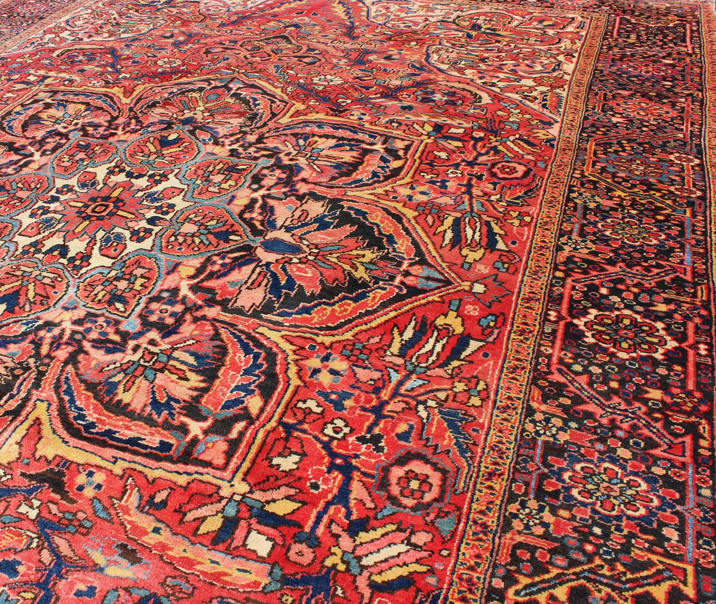 Large Semi antique Heriz with soft reds and multi - color midcentury Persian Heriz rug with stylized medallion design, rug rm - m17420, country of origin / type: Iran / Heriz, circa 1950. This magnificent antique Persian Heriz carpet from the mid - 20... - Keivan Woven ArtsRM - M17420 - 2163Rug