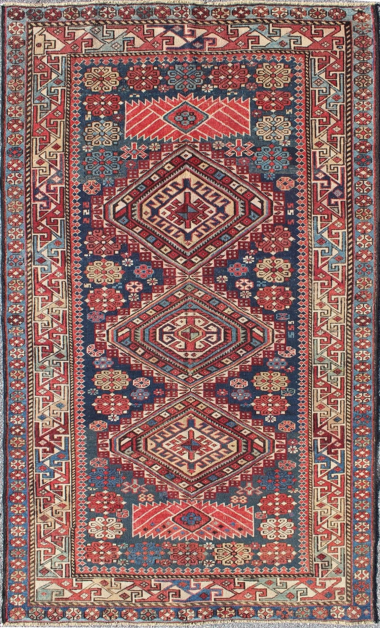 Antique Kazak Rug with In Multi Colors and Indigo Background. This antique, late 19th century Kazak rug from Russia displays three bold, geometric central medallions set on an indigo background and surrounded by multiple complementary geometric... - Keivan Woven ArtsS12 - 0517 - 3720Rug