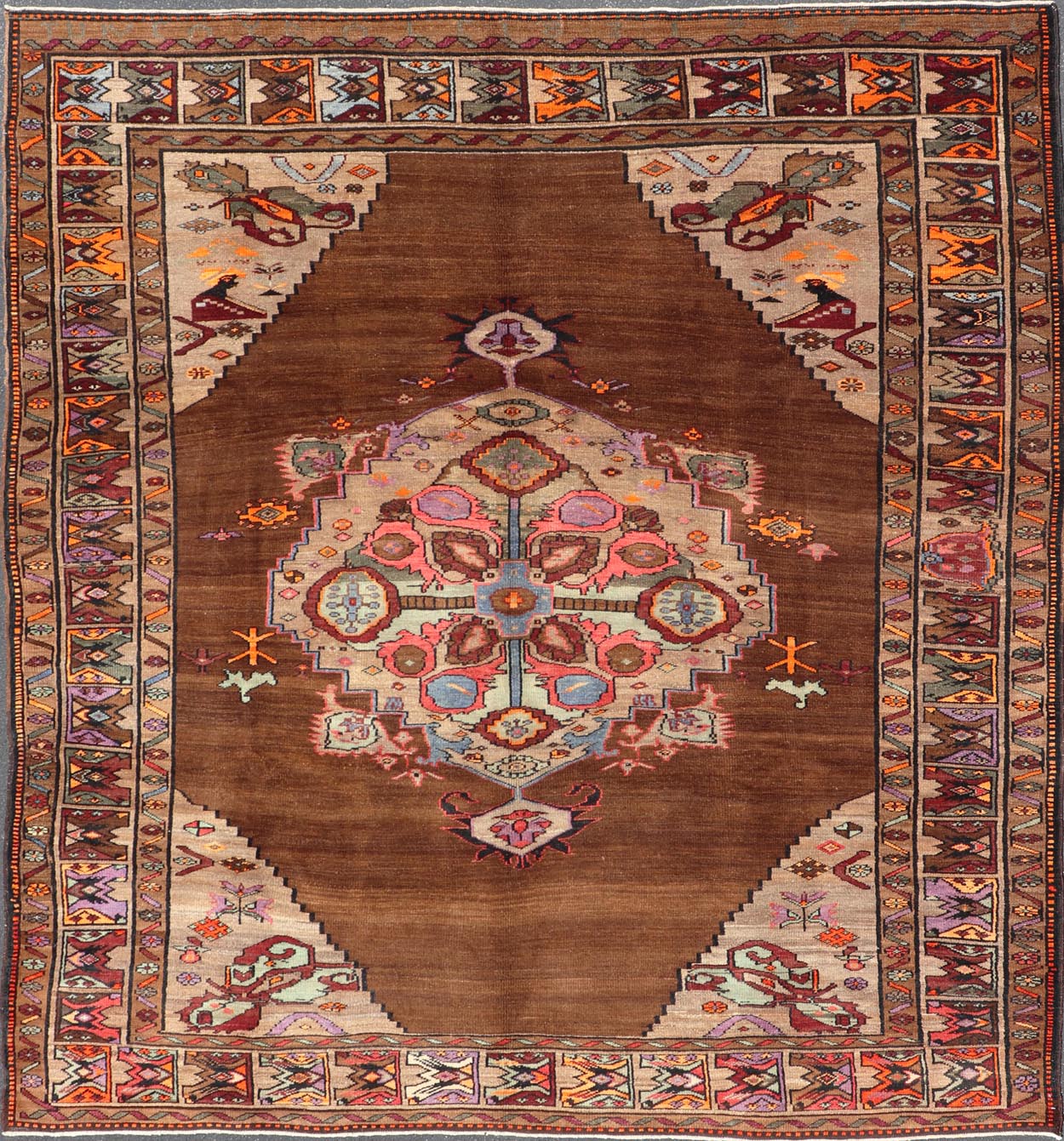 Vintage Turkish Kars Rug With Medallion On A Brown Field with Pops of Color. Keivan Woven Arts / rug/ TU - MTU - 3489, country of origin / type: Turkey / Oushak / Kars, circa 1940 Measures: 9'4 x 10'2. This Turkish Kars rug has been handwoven in Turk... - Keivan Woven ArtsTU - MTU - 3489 - 6853Rug