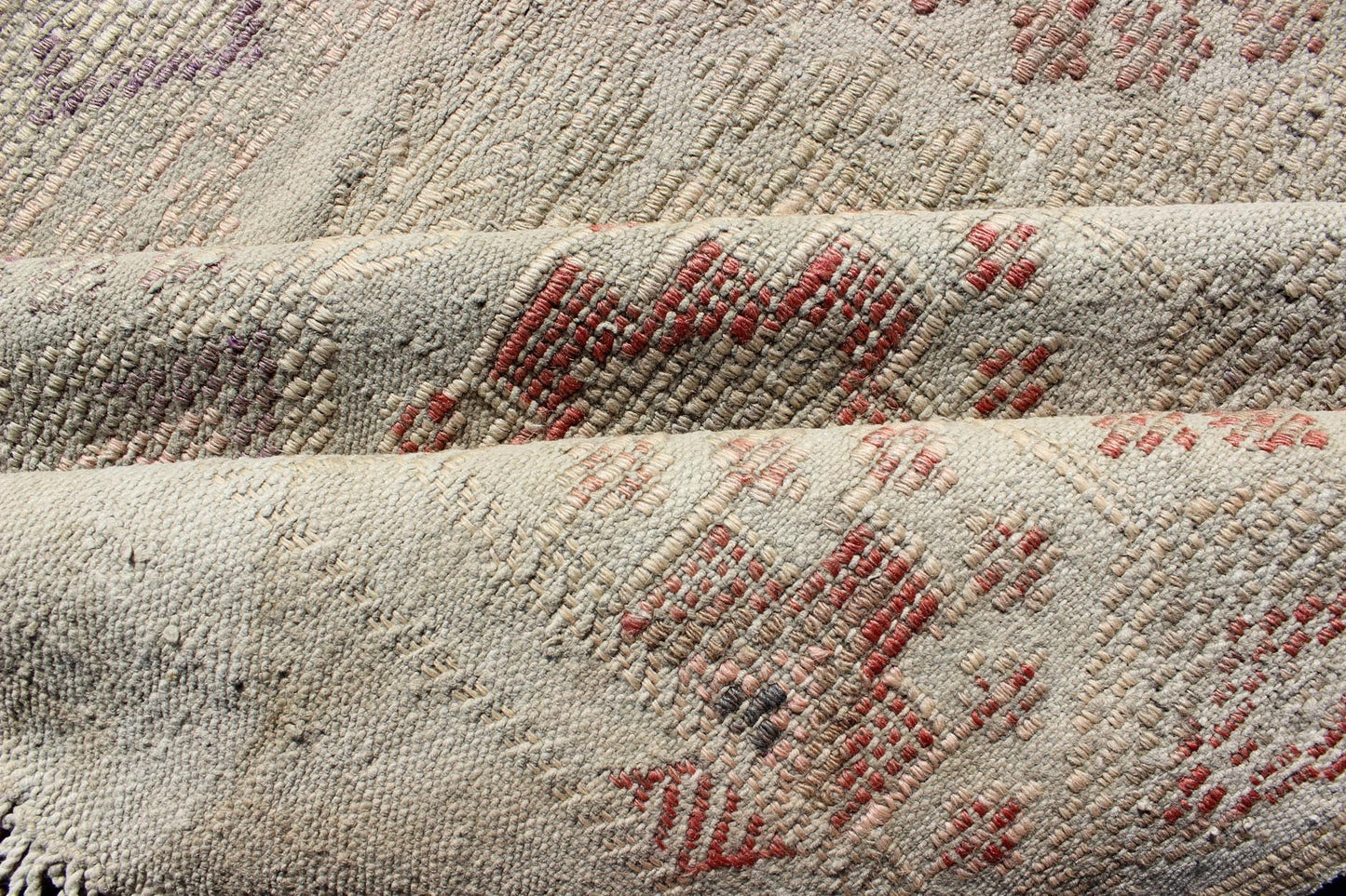 Vintage Turkish Kilim Featuring Muted Colors and All - Over Tribal Motif Design Measures 4'7 x 8'0 This rug features an asymmetrical design of tribal crests decorating the light blue - grey field. The crests are rendered in varying muted shades ... - Keivan Woven ArtsTU - NED - 136032 - 4618Rug