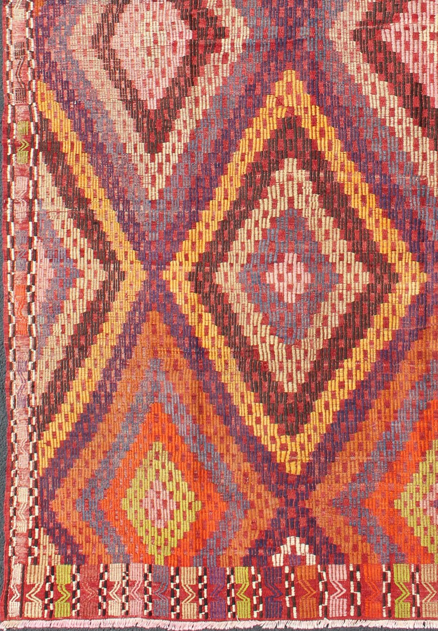 Measures: 5'7 x 10'5. Featuring a large diamond pattern with a spotted and speckled assortment of geometric checkered elements, this uniquely embroidered Kilim showcases an array saturated colors. The colors include blue, gray, red, yellow, brown, o... - Keivan Woven ArtsTU - NED - 561 - 6895Rug