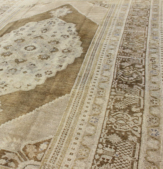 Vintage Turkish Floral Medallion Oushak Rug in Khaki and Brown Tones Measures: 5'11 x 9'6 Set on a khaki background and brown border, this vintage Turkish Oushak displays an unique earth tone color combination with various shades of taupe... - Keivan Woven ArtsTU - UGU - 11 - 3126