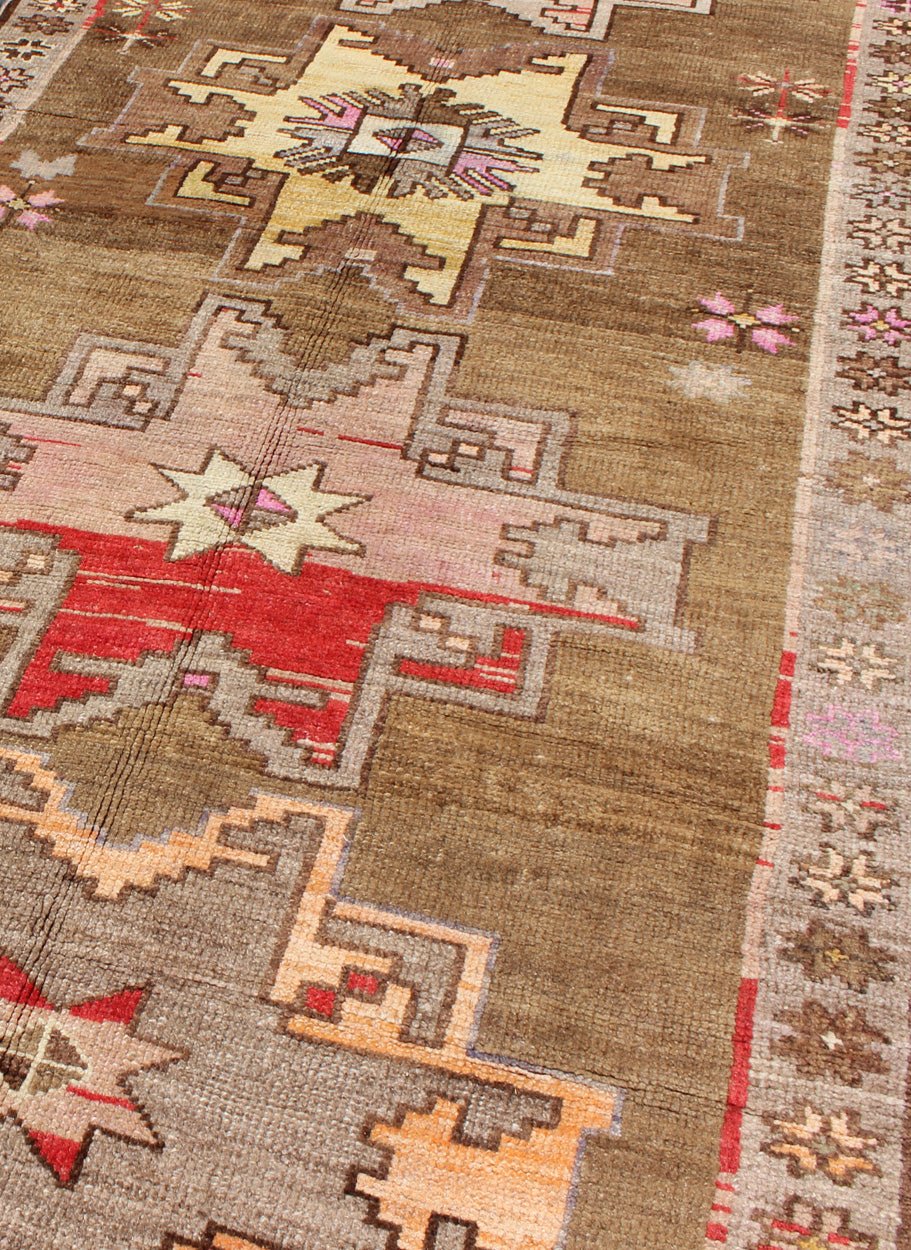 Unique & Colorful Turkish Kars Runner with Tribal Designs and Geometric Motifs Vintage Turkish runner in greenish Brown background, ivory border with accent colors, red, pink, tan, green, bright yellow, taupe, rug/TU - UGU - 4806, country of origin... - Keivan Woven ArtsTU - UGU - 4806 - 10287Rug