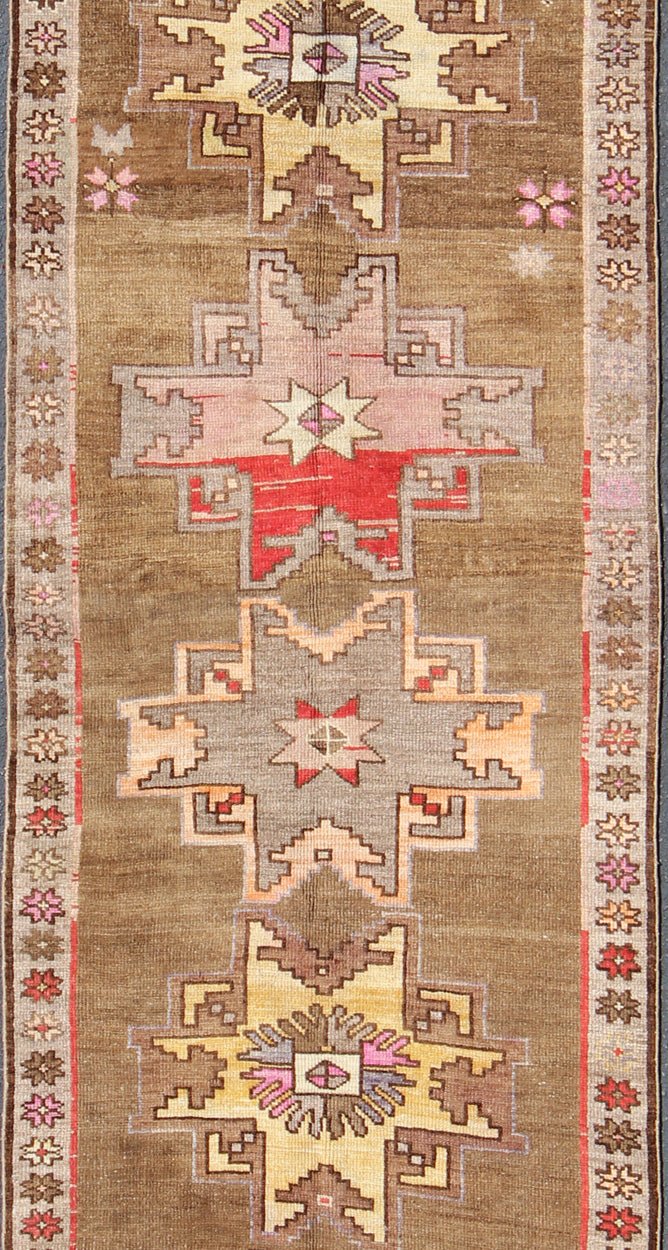 Unique & Colorful Turkish Kars Runner with Tribal Designs and Geometric Motifs Vintage Turkish runner in greenish Brown background, ivory border with accent colors, red, pink, tan, green, bright yellow, taupe, rug/TU - UGU - 4806, country of origin... - Keivan Woven ArtsTU - UGU - 4806 - 10287Rug