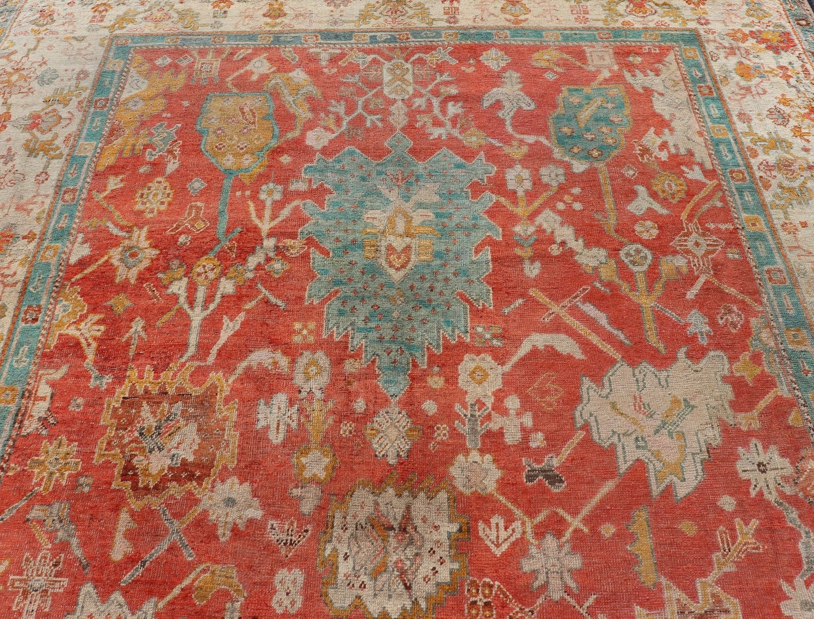 Antique Turkish Oushak In Tribal Motifs in Soft Coral, Blue, Marigold, and Cream Antique Turkish Oushak rug with tribal Medallion design in terracotta, blue, cream, and marigold. Keivan Woven Arts / rug / 17 - 1108 - K - 105, country of origin / type:... - Keivan Woven Arts17 - 1108 - K - 105 - 9272Rug