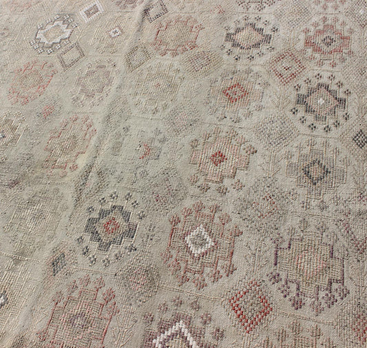 Vintage Turkish Kilim Featuring Muted Colors and All-Over Tribal Motif Design
 
 
 
 Measures 4'7 x 8'0 
 
 This rug features an asymmetrical design of tribal crests decorating the light blue-grey field. The crests are rendered in varying muted shades ...